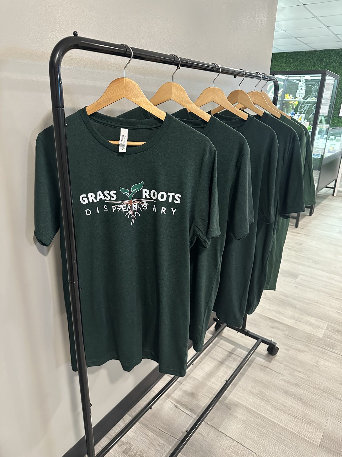 Grass Roots Dispensary t-shirts on the merch rack in store