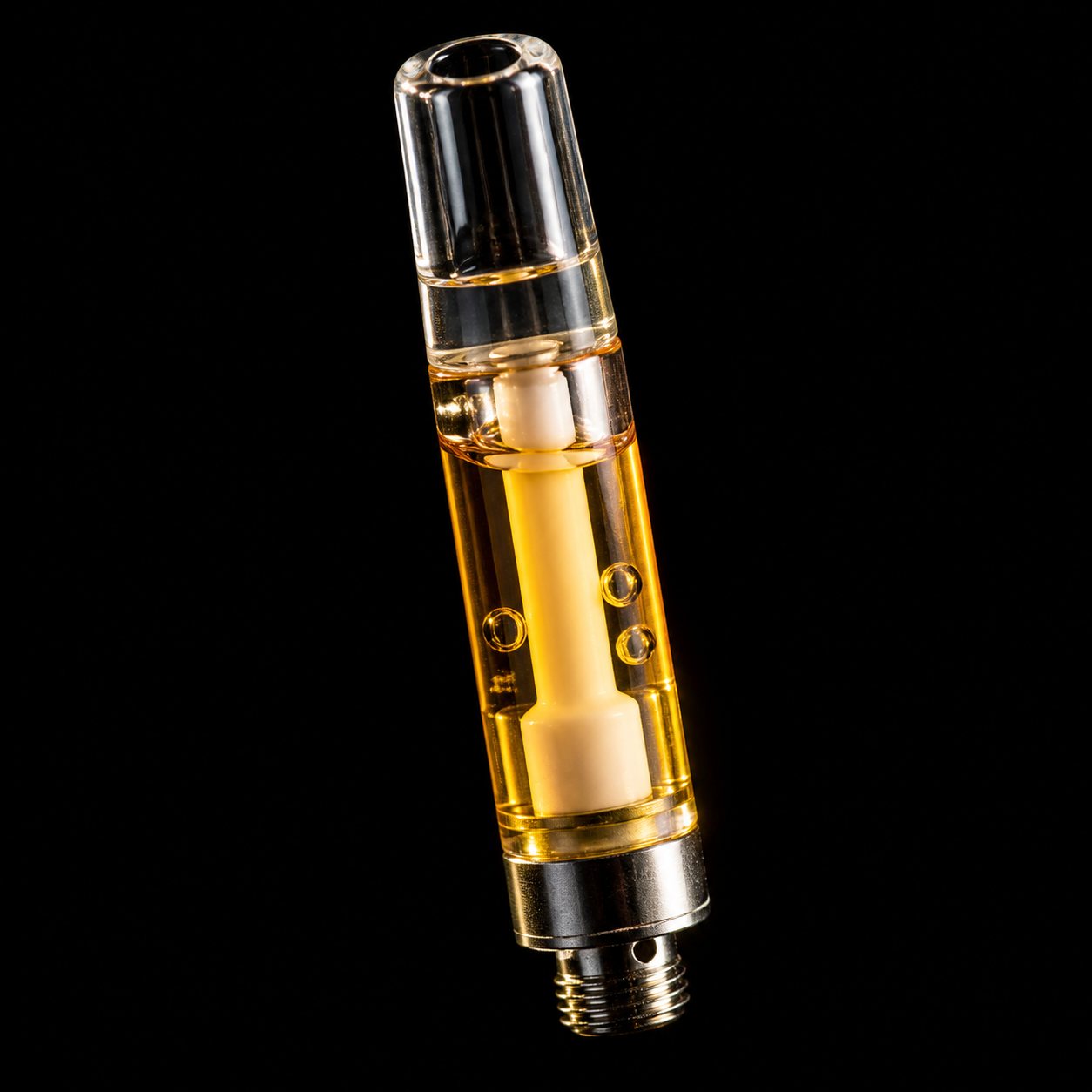 Close-up of a glass vape cartridge with golden cannabis oil and ceramic core
