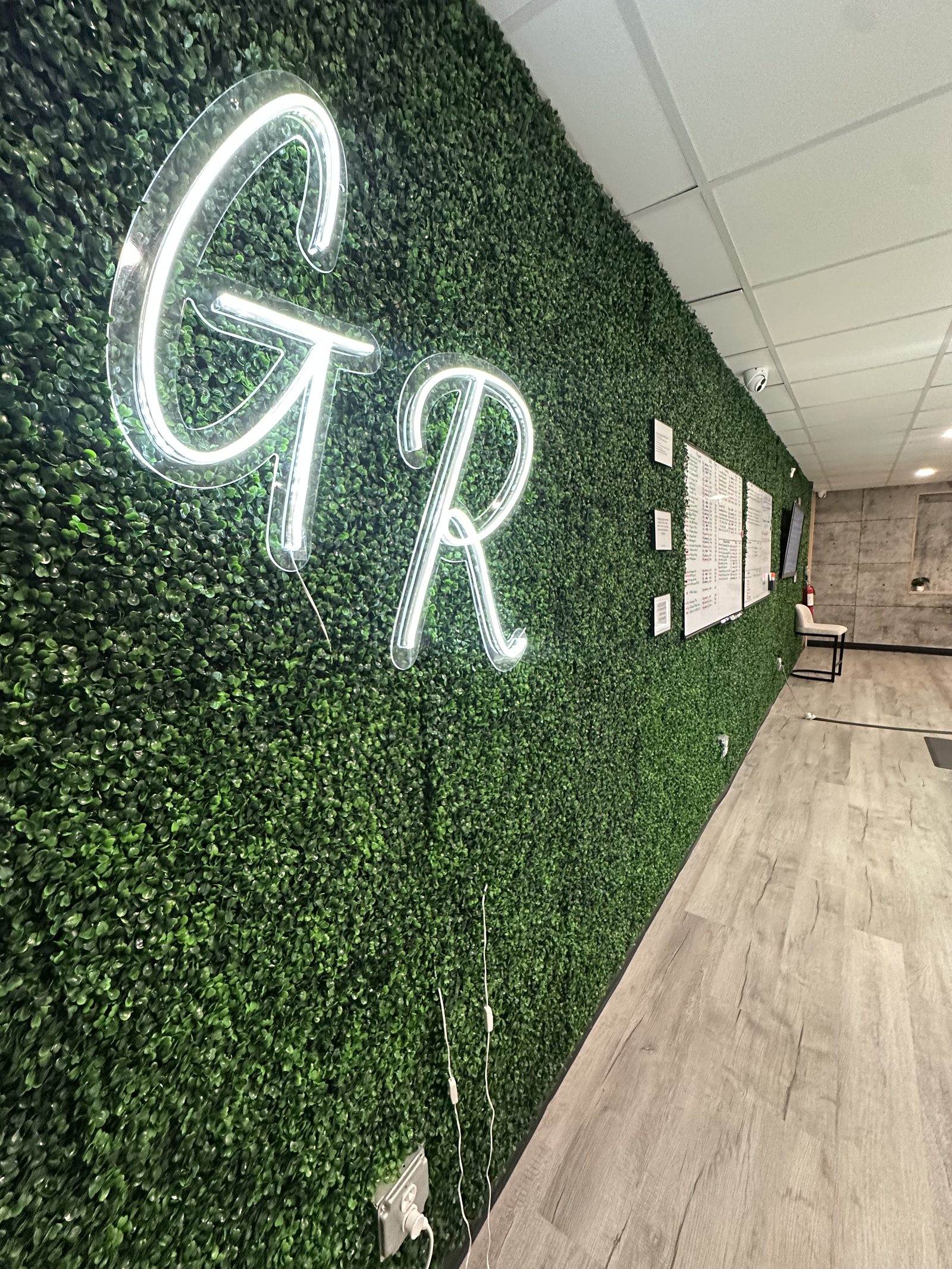 Moss wall and glowing GR sign inside Grass Roots